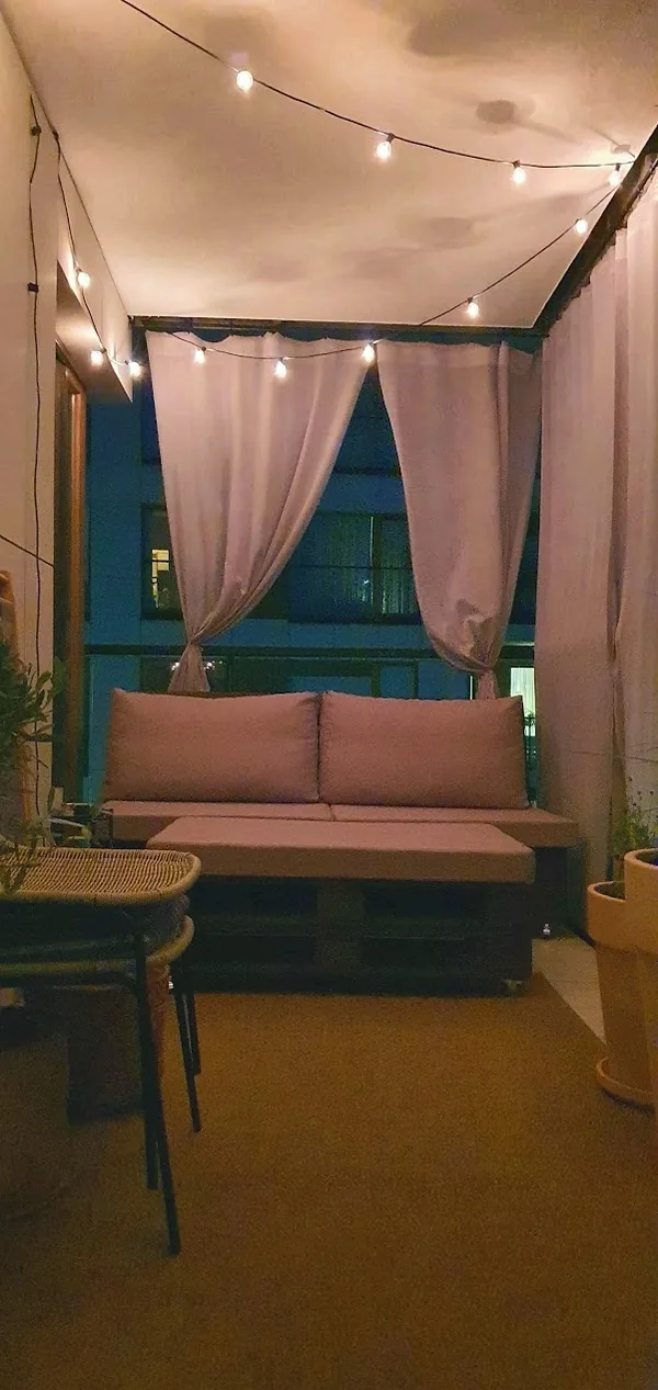 Taras wieczorem - sofa, zasłony, światła stringowe